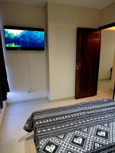 a bedroom with a bed and a television on the wall at Complejo Carrodilla4 in Ciudad Lujan de Cuyo