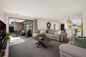 a living room with a couch and a table at Spacious Modern Retreat, Near Shops & Cafes in Queenstown