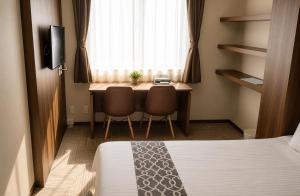 a room with a bed and a desk with two chairs at Sugamo Winco Residence 新宿まで電車14分 巣鴨駅徒歩3分 光wifi エレベーター 商店街徒歩4分 in Tokyo