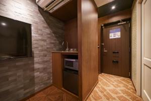 a small kitchen with a door and a television at Beautemps in Osaka