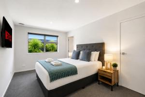 a bedroom with a large bed and a window at Spacious Modern Retreat, Near Shops & Cafes in Queenstown