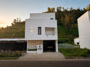 a white building on top of a hill at Singgah Sejenak Dieng in Diyeng