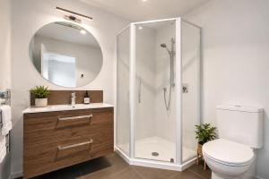 a bathroom with a shower and a toilet and a sink at Spacious Modern Retreat, Near Shops & Cafes in Queenstown +23 photos
