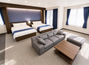 a hotel room with two beds and a couch at Sugamo Winco Residence 新宿まで電車14分 巣鴨駅徒歩3分 光wifi エレベーター 商店街徒歩4分 in Tokyo