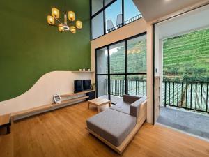a living room with a couch and a large window at Singgah Sejenak Dieng in Diyeng