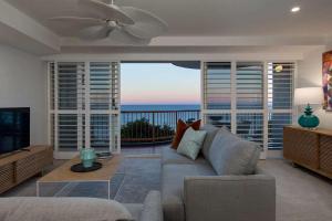 a living room with a couch and a view of the ocean at Beachfront Villa in Coolum Beach