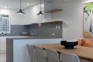 a kitchen with a wooden table and chairs at Beachfront Villa in Coolum Beach