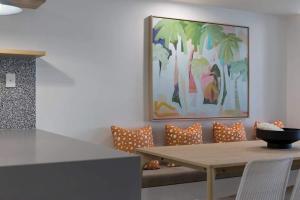 a dining room with a table and a painting at Beachfront Villa in Coolum Beach +27 photos