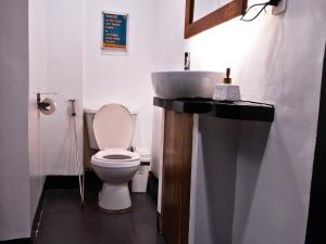a bathroom with a white toilet and a sink at Outpost Beach Hostel in El Nido +11 photos