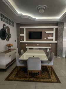 a dining room with a table and chairs and a tv at Casa Quinta Locha in Ciudad del Este