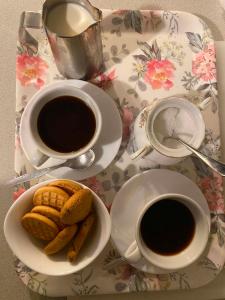 a table with two cups of coffee and a plate of cookies at B&B LOKEV Lipica HostelSezana in Lokev