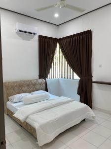 a bedroom with a large bed with a window at PL Homestay 2 in Padang Lembu