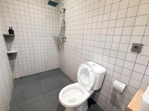 a bathroom with a toilet and a tiled wall at Singgah Sejenak Dieng in Diyeng +17 photos