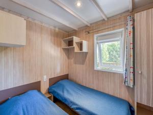 a small bedroom with a blue bed and a window at Cottage, animaux acceptés - 6 pers. - API-1-52-2931 in Lamonzie-Montastruc +28 photos