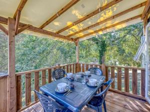 a table on a wooden deck with chairs on it at Cottage, animaux acceptés - 6 pers. - API-1-52-2931 in Lamonzie-Montastruc