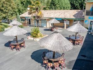 a group of tables and chairs with umbrellas at Cottage, animaux acceptés - 6 pers. - API-1-52-2931 in Lamonzie-Montastruc