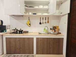 a kitchen with wooden cabinets and a sink at Sunday House - Fisherman Village Samui in Bophut