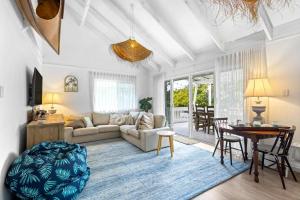 a living room with a couch and a table at Barra Luxe Beach House 4BR Yaroomba Beach Stay in Yaroomba
