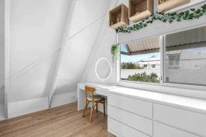 a white bathroom with a sink and a window at Barra Luxe Beach House 4BR Yaroomba Beach Stay in Yaroomba