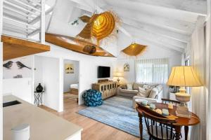 a living room with a couch and a table at Barra Luxe Beach House 4BR Yaroomba Beach Stay in Yaroomba