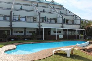 a hotel with a swimming pool in front of a building at Dumela Margate Flat No 5 in Margate