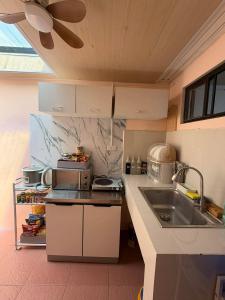 a kitchen with a sink and a counter top at Maple Tree by The Guild Oasis Transient House in Rosario