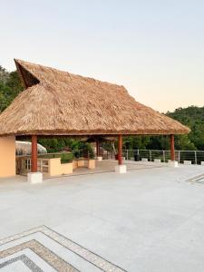 a large straw roofed pavilion with a table at Villa Linda in Acapulco