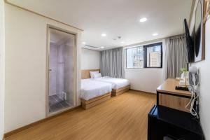 a bedroom with a bed and a glass shower at Bliss Hotel Myeongdong in Seoul