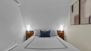 a bedroom with a white bed with a blue pillow at Waterfront, Hot Tub, Dock Kayaks, Movie Game Room in Lake Ariel
