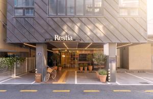 a facade of a building with a sign that reads riesta at Restia Hotel Suwon Station in Suwon