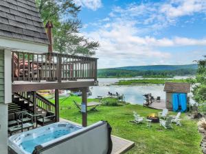 a deck with a hot tub on the side of a house at Waterfront, Hot Tub, Dock Kayaks, Movie Game Room in Lake Ariel