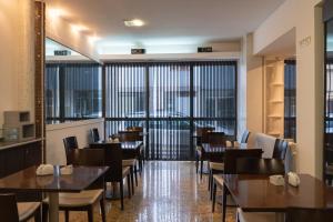 a restaurant with tables and chairs and large windows at Zoom Apartments Hotel in Córdoba