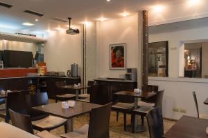 a restaurant with tables and chairs and a tv at Zoom Apartments Hotel in Córdoba