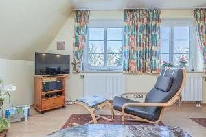 a living room with a chair and a television at Fewo-Inselblick in Nordstrand