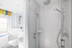 a white bathroom with a shower and a toilet at Fewo-Inselblick in Nordstrand +20 photos