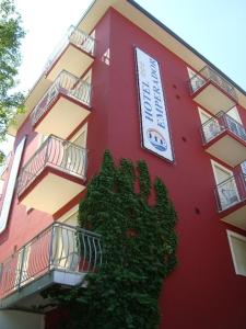 un edificio rojo con un cartel en el costado en Hotel Emperador en Lido di Jesolo