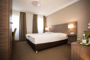 a hotel room with a large bed and a window at Hotel Wagner Am Marktplatz in Bad Wimpfen