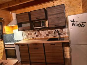 a kitchen with a refrigerator and a microwave at Domek Nad Morzem in Kołobrzeg +21 photos