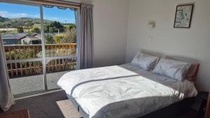 a bedroom with a bed and a large window at Turanga Heights in Gisborne