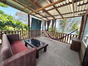 a living room with a couch and a table on a balcony at Coco cabañas Tela in El Triunfo de la Cruz +5 photos