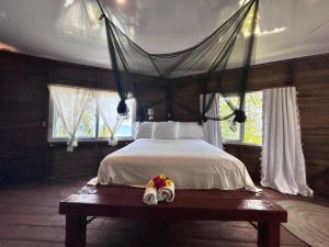 a bedroom with a bed with a canopy at Coco cabañas Tela in El Triunfo de la Cruz