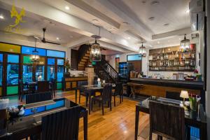 a restaurant with tables and chairs and a bar at De Lanna Hotel in Chiang Mai