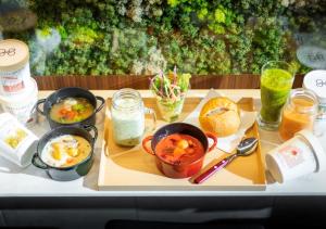 a tray with bowls of food and drinks on a table at Super Hotel Premier Ginza in Tokyo