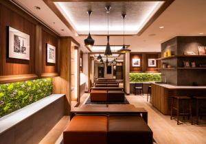 a lobby with a bar with benches and plants at Super Hotel Premier Ginza in Tokyo