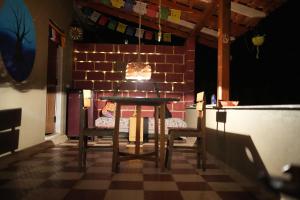 a table and chairs in a room with a brick wall at Secret Ashram Coorg in Kushālnagar