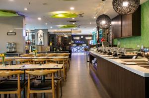 a restaurant with wooden chairs and a bar at Opulent Nights Sky Hotel 2BR Family Stay KK in Kota Kinabalu