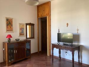 a room with a tv and a wooden table with a television at Oasi Baia Verde in Baia Verde