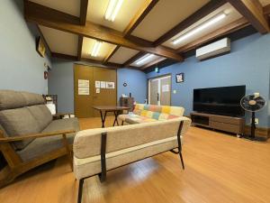 a living room with a couch and a flat screen tv at Dons House in Fukuoka