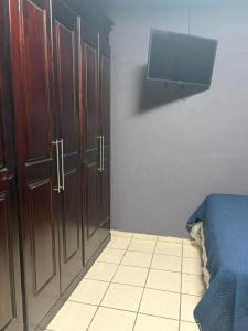 a bedroom with wooden cabinets and a tv on the wall at Enjoy Cabo del Sol Costa del Sol in El Zapote