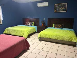 a bedroom with two beds with green sheets at Enjoy Cabo del Sol Costa del Sol in El Zapote +114 photos
